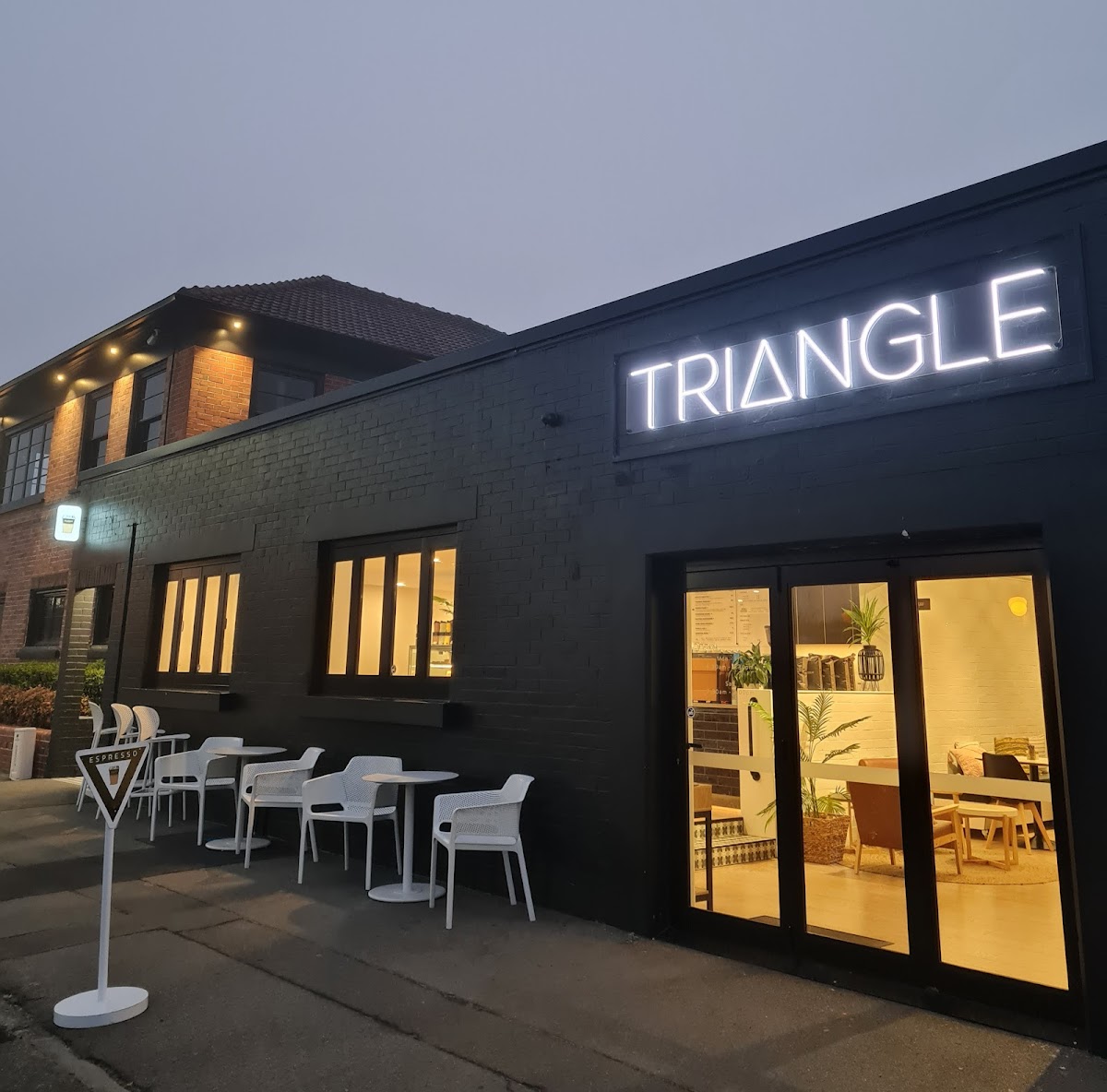 Triangle Espresso storefront lit at blue hour