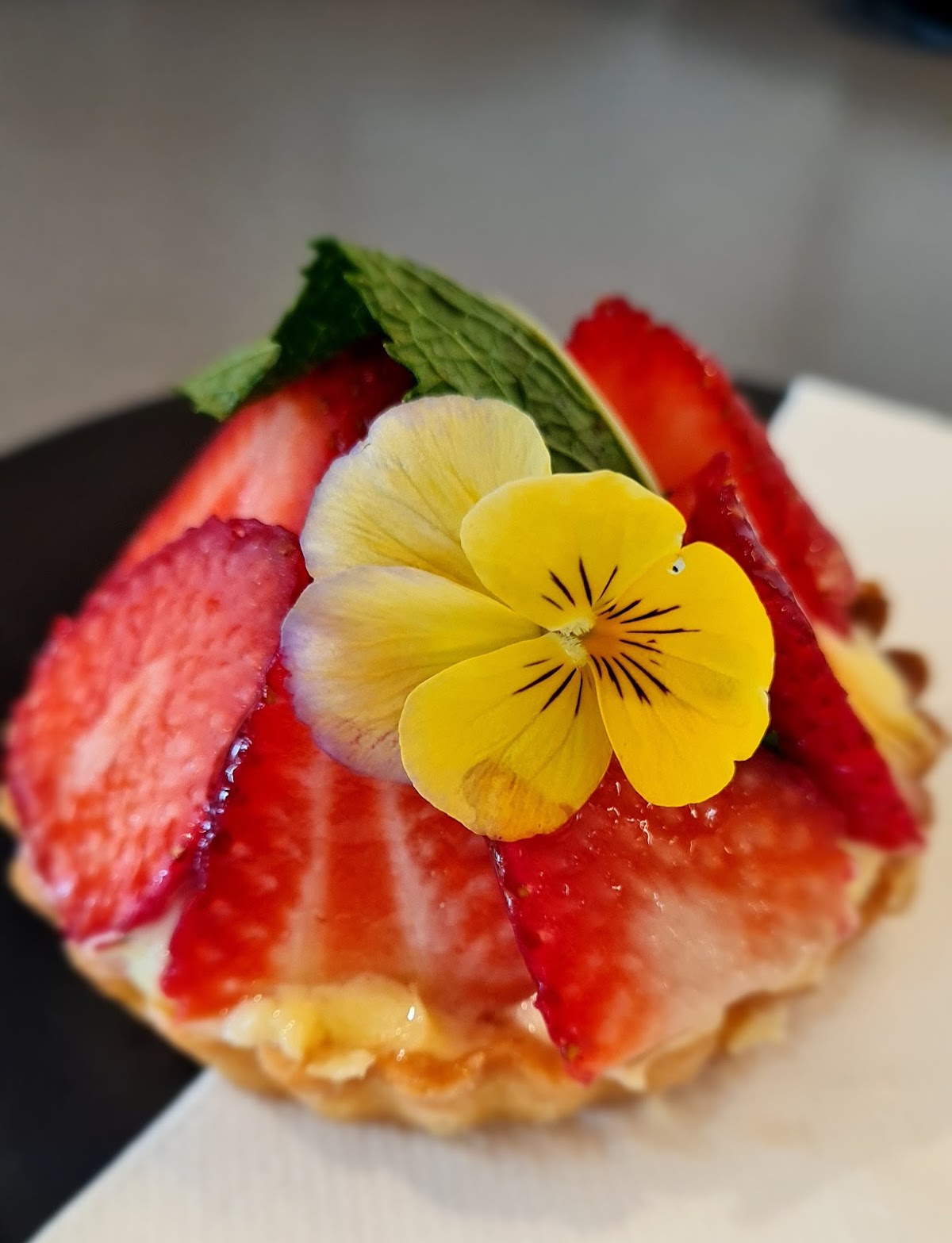 Strawberry tart topped with an edible flower